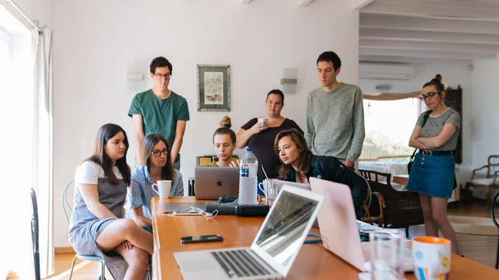 Group of young professionals engaged in a collaborative meeting in a modern office setting.