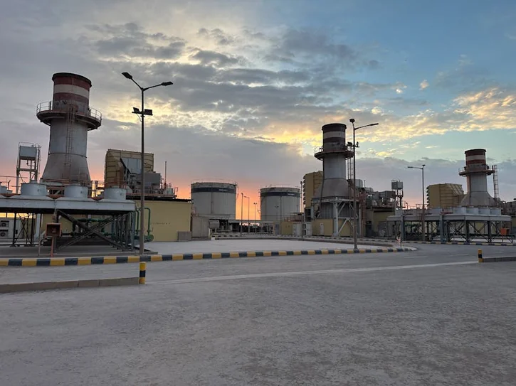 A striking view of an industrial factory during sunrise in Saudi Arabia with a colorful sky.