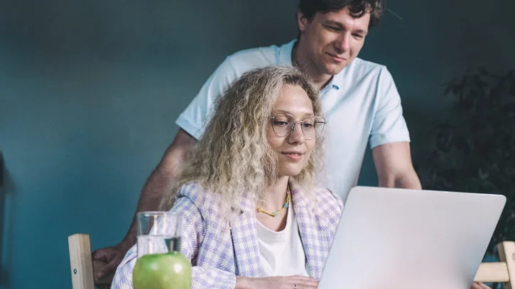 ラップトップとフォルダを使ってプロジェクトに取り組む男女