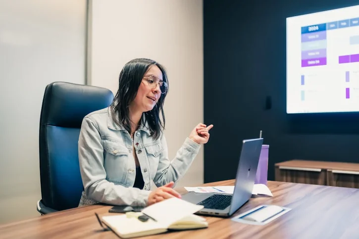 A focused businesswoman delivering a presentation in a modern office setting. Ideal for business and corporate themes.