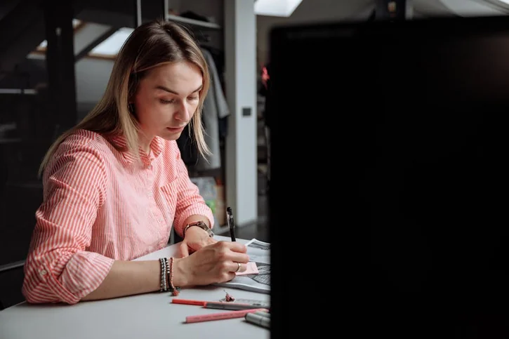 Creative professional woman focused on design work at her office desk.