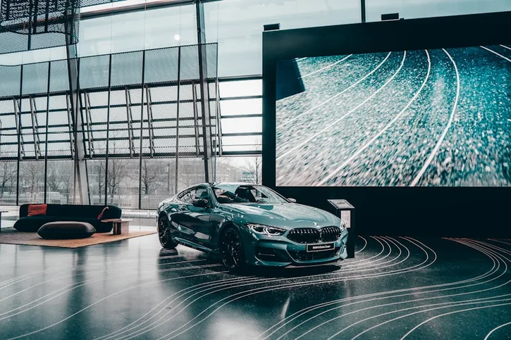 Elegant luxury coupe showcased in a modern Munich auto showroom with glass architecture.