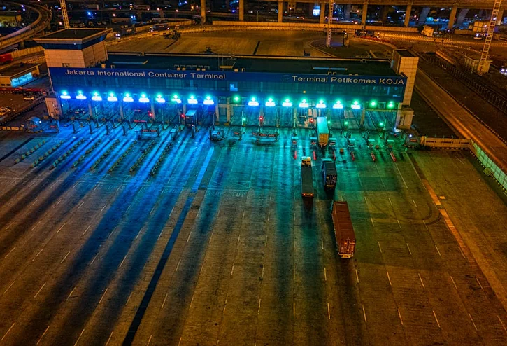 Illuminated aerial view of Jakarta International Container Terminal highlighting logistics activity at night.