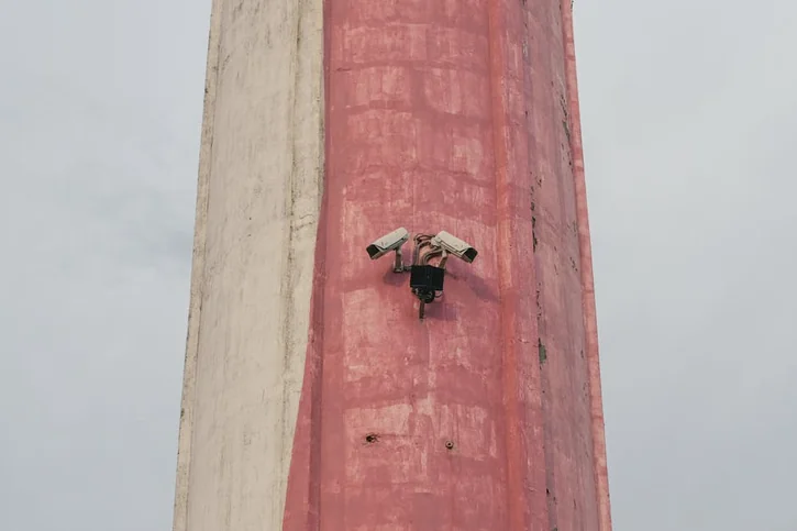 Two security cameras mounted on a tall urban structure in Bratislava.