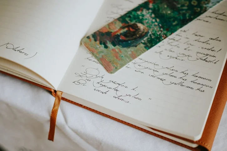 A close-up of an open journal with handwritten text and a colorful bookmark, evoking creativity.