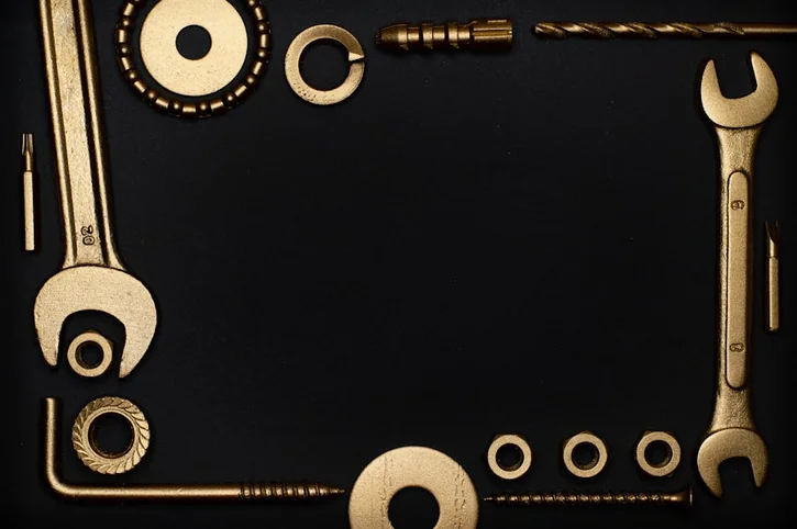 Artistic arrangement of golden tools on a black background with ample copy space for text.