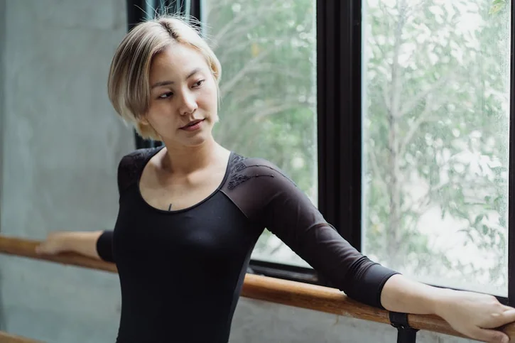 A graceful dancer practicing by a window, showcasing elegance and confidence.