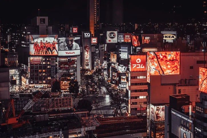 Vibrant night scene of Shibuya, Tokyo with illuminated billboards and busy streets.