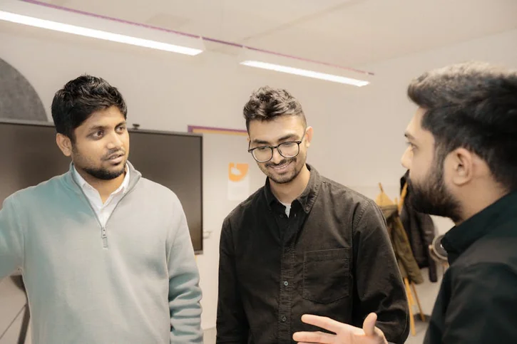 Three men discussing in office setting