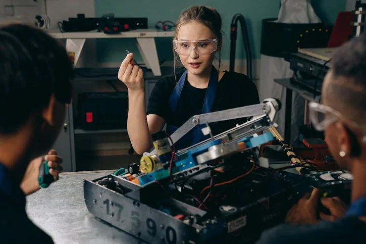 Young engineers working together on a robotics project in a workshop, focusing on innovation and teamwork.